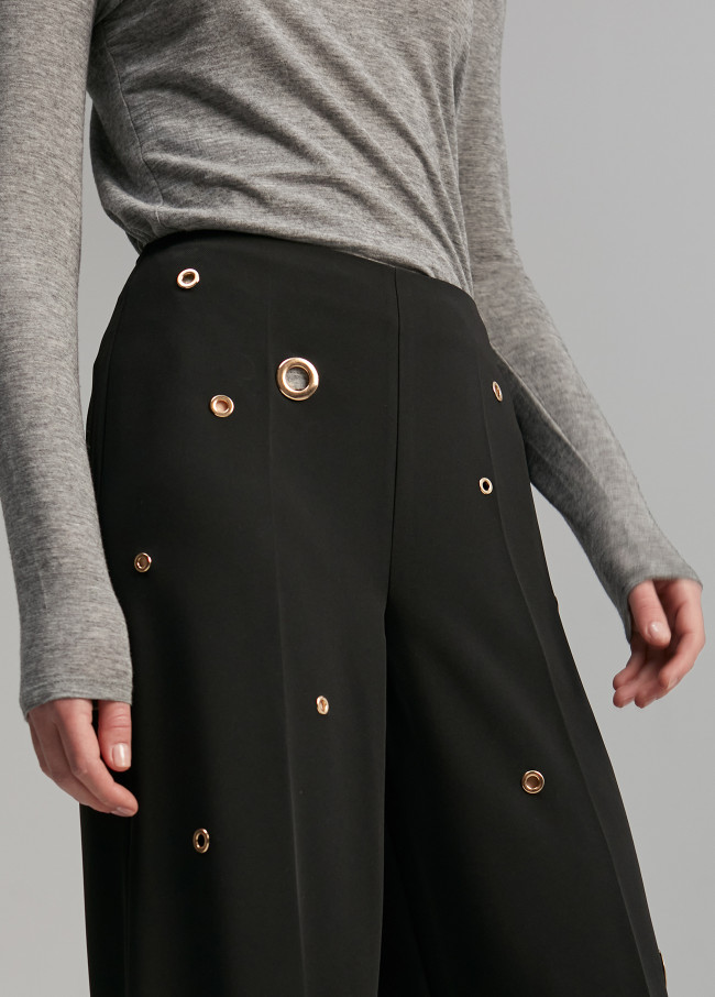 Trousers with eyelets detail