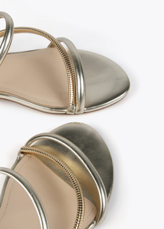 Flache Sandalen mit metallisierten Lederriemen und goldfarbenem Absatz