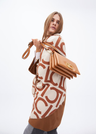 Faux leather crossbody bag with three compartments and flap.