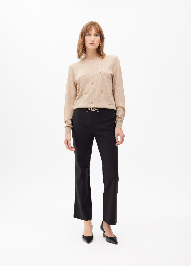 Pantalón campanita cropped con detalle joya en...