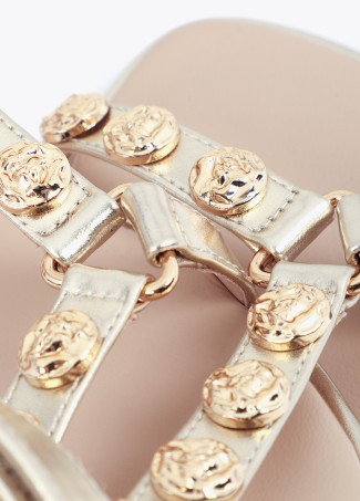 Flache Sandale mit metallischen Riemen und goldenen Applikationen