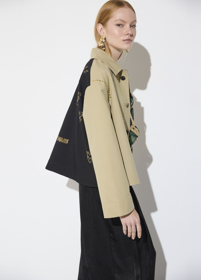 Trench curto bicolor com detalhes de tachas
